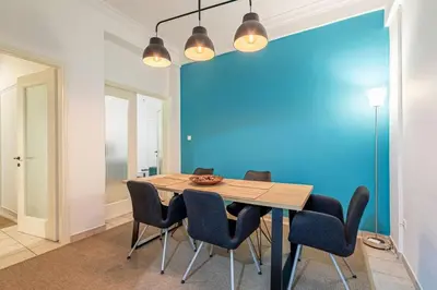 a dining room with a blue wall and a table and chairs at Acropolis Stylish 2BR Apartment - Center of Athens in Athens