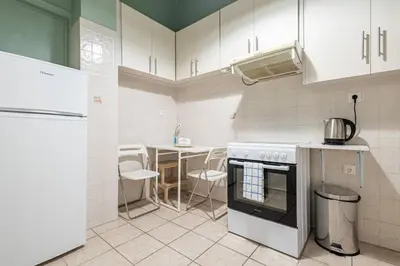 a kitchen with white cabinets and a stove top oven at Acropolis Stylish 2BR Apartment - Center of Athens in Athens