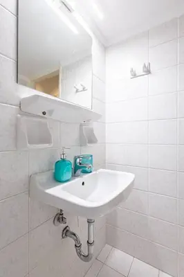 a white bathroom with a sink and a mirror at Acropolis Stylish 2BR Apartment - Center of Athens in Athens