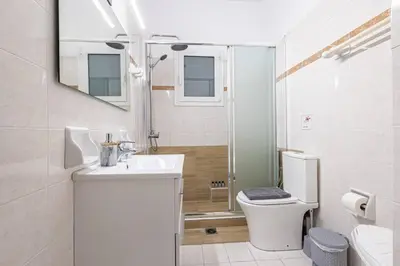 a white bathroom with a toilet and a sink at Acropolis Stylish 2BR Apartment - Center of Athens in Athens