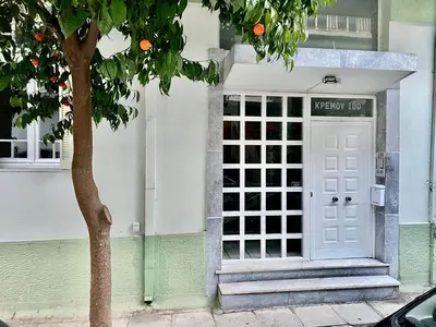 a white door on a building with an orange tree at CK apartment view acropole in Athens