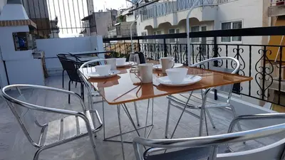 a table with cups and saucers on a balcony at Maisonaitte-Athens Center, 4 BD, 2 BATH in Athens