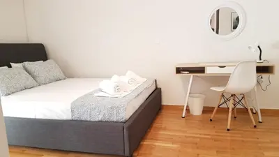 a bedroom with a bed and a desk and a chair at Maisonaitte-Athens Center, 4 BD, 2 BATH in Athens