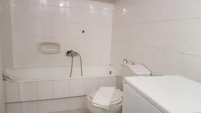 a white bathroom with a toilet and a bath tub at Maisonaitte-Athens Center, 4 BD, 2 BATH in Athens