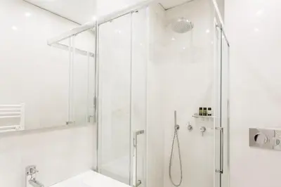 a white bathroom with a shower and a sink at Athens Observatory Suite in Athens