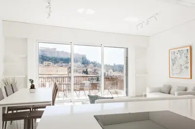 a white living room with a table and a large window at Athens Observatory Suite in Athens