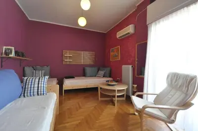 a bedroom with purple walls and a living room at Nice Apartment Near City Center in Athens