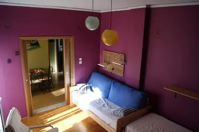 a living room with a blue couch in a purple wall at Nice Apartment Near City Center in Athens