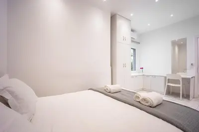 a white bedroom with a bed with towels on it at Cozy apartment in the center of Athens in Athens