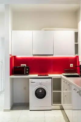 a kitchen with a washing machine and a red wall at Cozy apartment in the center of Athens in Athens