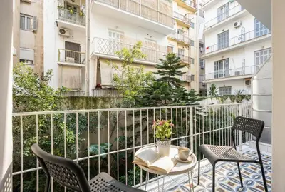 a balcony with chairs and a table with a book at Cozy apartment in the center of Athens in Athens