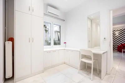 a white kitchen with a white table and a window at Cozy apartment in the center of Athens in Athens