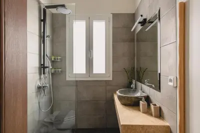 a bathroom with a sink and a toilet and a window at Living Stone Aparthotel in Athens