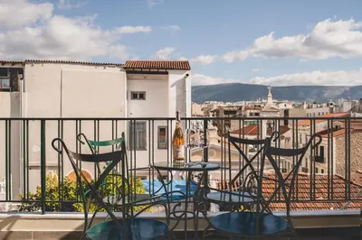 a balcony with two chairs and a bottle of wine at Living Stone Aparthotel in Athens