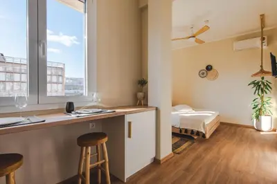 a room with a bar and a bed and a window at Living Stone Aparthotel in Athens