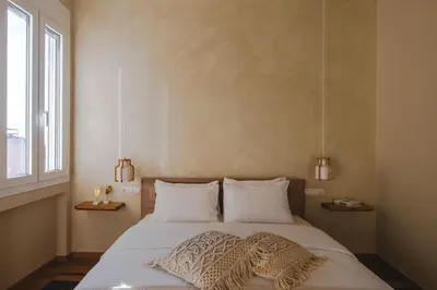 a bedroom with a bed with two pillows and a window at Living Stone Aparthotel in Athens