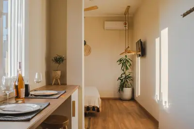 a dining room with a table with plates and wine glasses at Living Stone Aparthotel in Athens