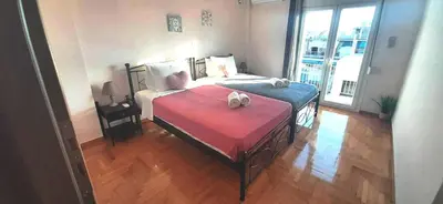 a bedroom with a large bed with a red blanket at Sirens Athens Apartment in Athens