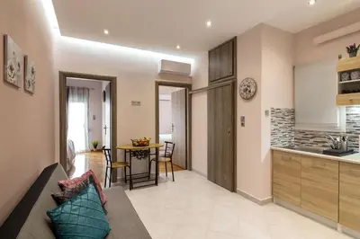 a living room with a couch and a kitchen at Sirens Athens Apartment in Athens