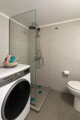 a washing machine in a bathroom with a shower at Sirens Athens Apartment in Athens