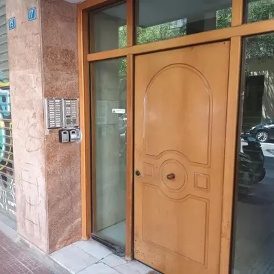 an entrance to a building with a wooden door at Sirens Athens Apartment in Athens