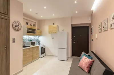 a kitchen with a couch and a refrigerator at Sirens Athens Apartment in Athens