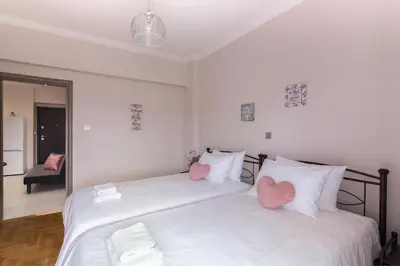 a bedroom with a bed with two hearts on the pillows at Sirens Athens Apartment in Athens