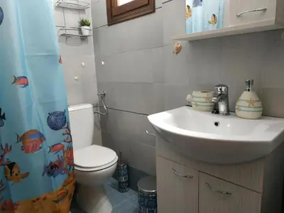 a bathroom with a sink and a toilet and a shower curtain at Παραθαλασσιο στουντιο Μιχαλιας Sea view studio Michalias Νουμερο 8 in Agia Marina Aegina