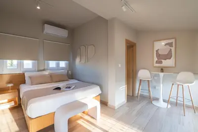 a bedroom with a bed and two chairs in it at My Greek Vacations City Apartments in Athens