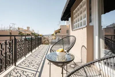 a table and chairs on a balcony with a cup of coffee at My Greek Vacations City Apartments in Athens