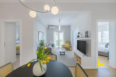 a living room with a table and a living room with a tv at Sun-Splashed 2-BDR Corner Apartment with Hillside views! in Athens
