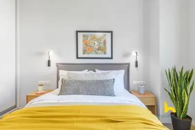 a bedroom with a bed with a yellow blanket at Sun-Splashed 2-BDR Corner Apartment with Hillside views! in Athens