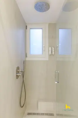 a bathroom with a shower and two windows at Sun-Splashed 2-BDR Corner Apartment with Hillside views! in Athens