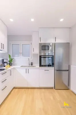 a kitchen with white cabinets and stainless steel appliances at Sun-Splashed 2-BDR Corner Apartment with Hillside views! in Athens