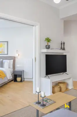a living room with a bed and a flat screen tv at Sun-Splashed 2-BDR Corner Apartment with Hillside views! in Athens