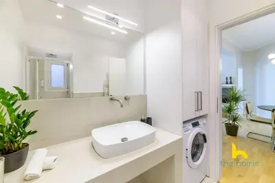 a bathroom with a sink and a washing machine at Sun-Splashed 2-BDR Corner Apartment with Hillside views! in Athens