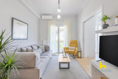 a living room with a couch and a tv at Sun-Splashed 2-BDR Corner Apartment with Hillside views! in Athens