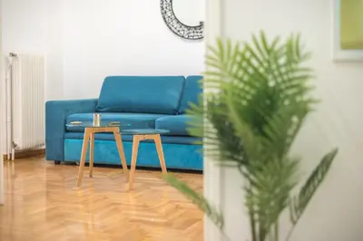 a blue couch and two tables in a living room at Athens Dreams & Suites Apartments in Athens