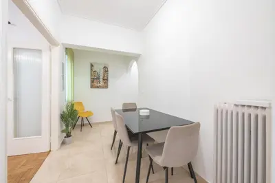a dining room with a table and chairs and a radiator at Athens Dreams & Suites Apartments in Athens
