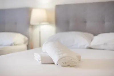 a roll of white towels sitting on a bed at Athens Dreams & Suites Apartments in Athens