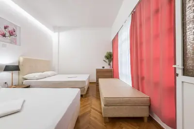 a room with two beds and a red curtain at Victoria Prestige Suites Apartments in Athens