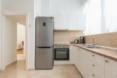 a stainless steel refrigerator in a kitchen with white cabinets at Victoria Prestige Suites Apartments in Athens