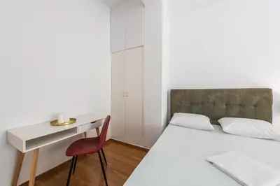 a bedroom with a bed and a desk and a chair at Victoria Prestige Suites Apartments in Athens
