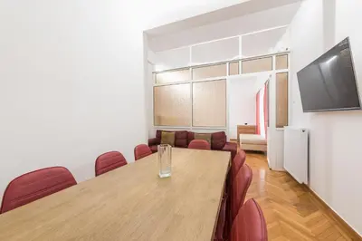 a conference room with a wooden table and red chairs at Victoria Prestige Suites Apartments in Athens