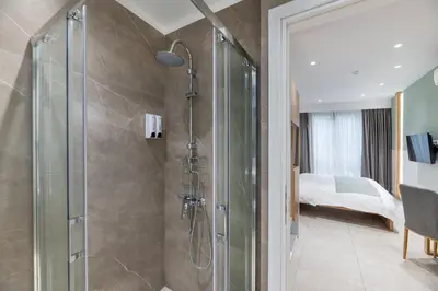 a bathroom with a shower and a bedroom at STARLA STUDIOS in Athens