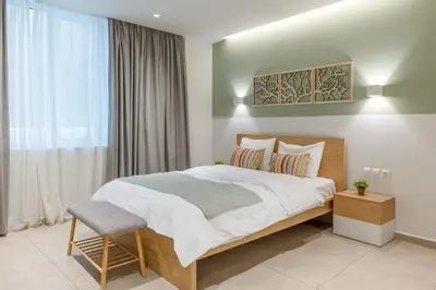 a bedroom with a large bed and a chair at STARLA STUDIOS in Athens