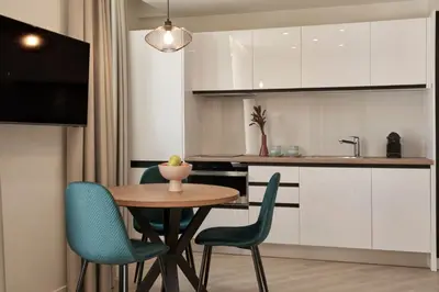 a kitchen with a table and blue chairs in a room at Hestia - Asklipiou 61 in Athens