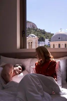 a man and a woman laying in bed at Hestia - Asklipiou 61 in Athens