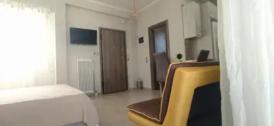 a room with a bed and a yellow chair in it at Experience a nice view appartment-heart of Athens in Athens