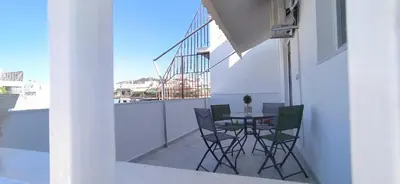a patio with a table and chairs on a balcony at Experience a nice view appartment-heart of Athens in Athens